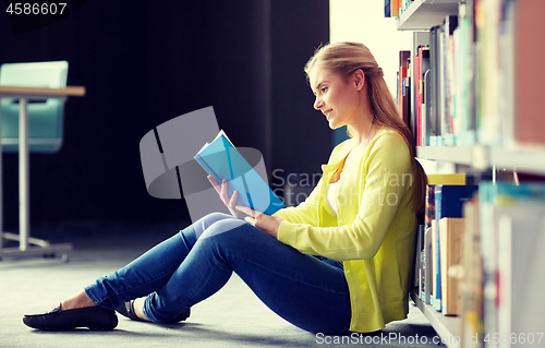 Image of high school student girl reading book at library