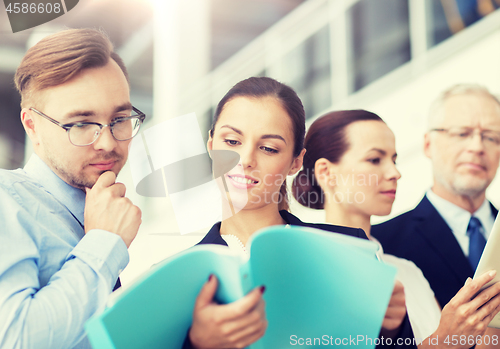 Image of business team with folders meeting at office