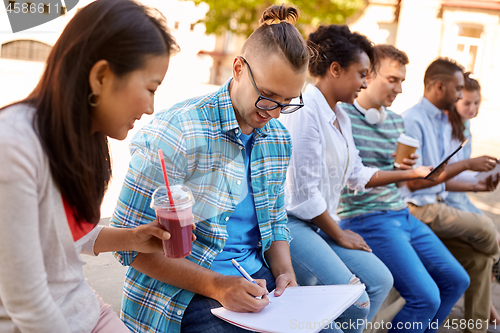 Image of group of happy students with notebook and drinks