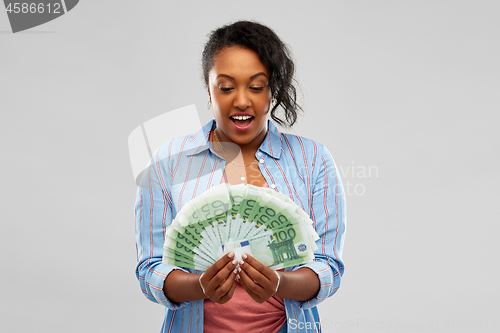 Image of surprised african american woman with euro money