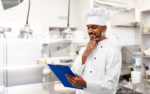 Image of indian chef with clipboard at restaurant kitchen