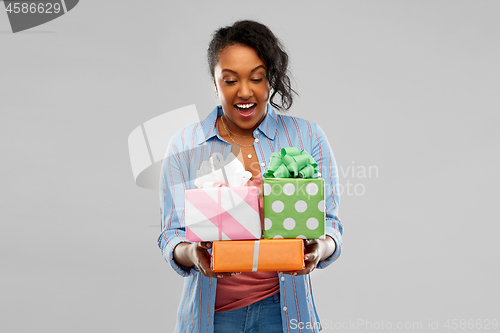 Image of happy african american woman with birthday gifts