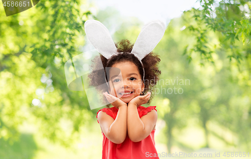 Image of happy little girl wearing easter bunny ears posing