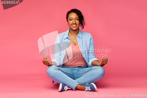 Image of happy african american woman in yoga lotus pose