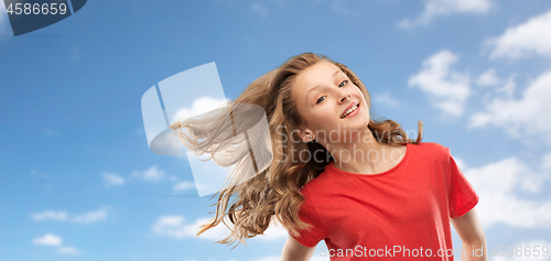 Image of smiling teenage girl in red with long wavy hair