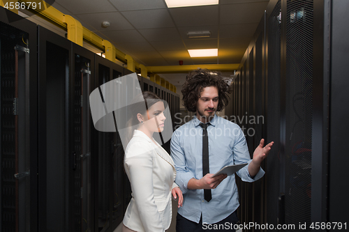 Image of engineer showing working data center server room to female chief