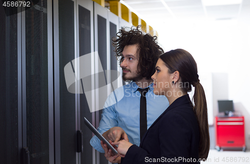 Image of engineer showing working data center server room to female chief