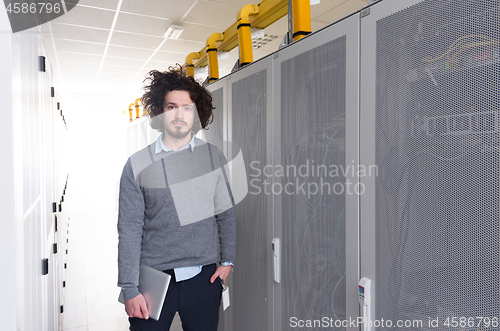 Image of IT engineer working on a tablet computer in server room