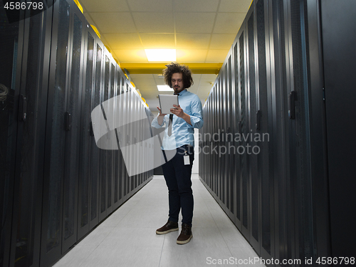 Image of IT engineer working on a tablet computer in server room