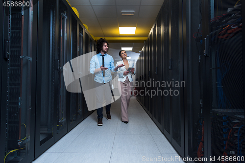 Image of engineer showing working data center server room to female chief