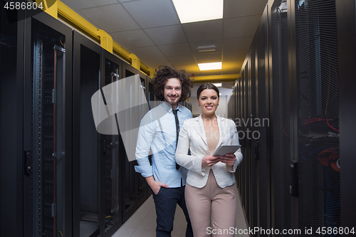 Image of engineer showing working data center server room to female chief