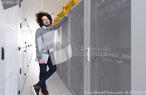 Image of IT engineer working on a tablet computer in server room