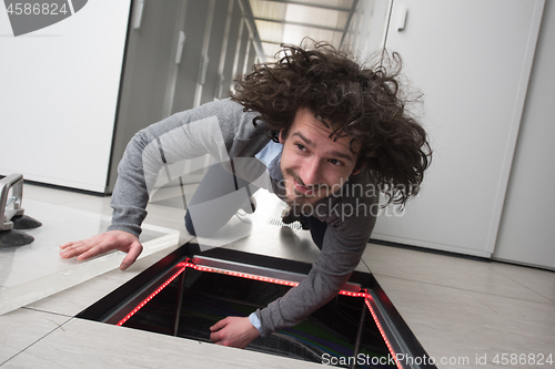 Image of engineer connecting cables in server room