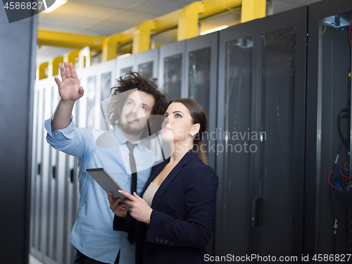 Image of engineer showing working data center server room to female chief