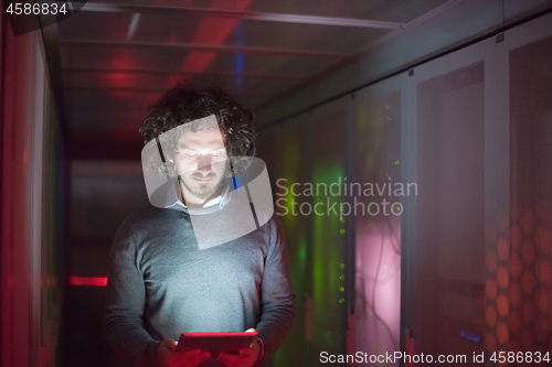 Image of IT engineer working on a tablet computer in server room