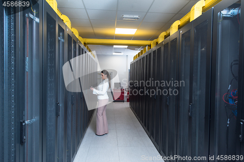 Image of Female engineer working on a tablet computer in server room