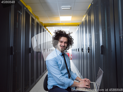 Image of engineer working on a laptop in server room