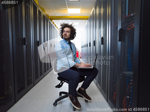 Image of engineer working on a laptop in server room