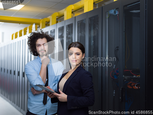 Image of engineer showing working data center server room to female chief