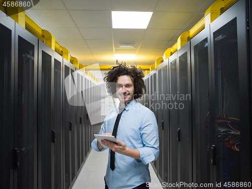 Image of IT engineer working on a tablet computer in server room