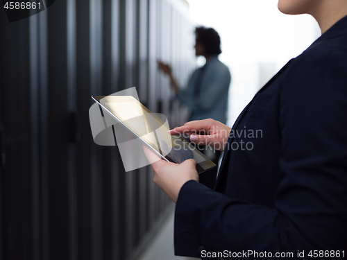 Image of Female engineer working on a tablet computer in server room