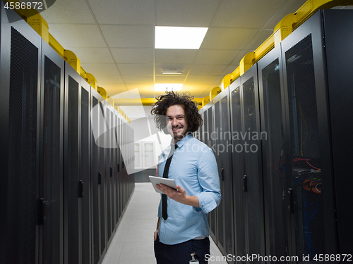 Image of IT engineer working on a tablet computer in server room