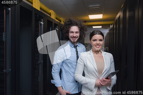 Image of engineer showing working data center server room to female chief