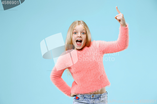 Image of Beautiful teen girl looking suprised isolated on blue