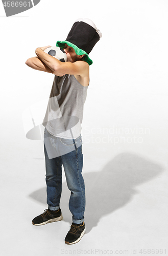Image of The young football fan - man hugging soccer ball isolated on a white background