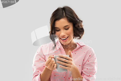 Image of happy young woman in pajama with mug of coffee