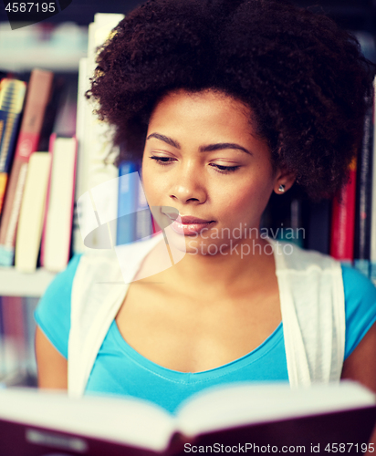 Image of african student girl reading book at library