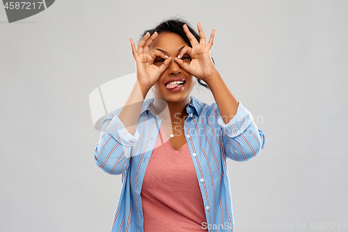 Image of african woman looking through finger glasses