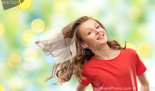 Image of smiling teenage girl in red with long wavy hair