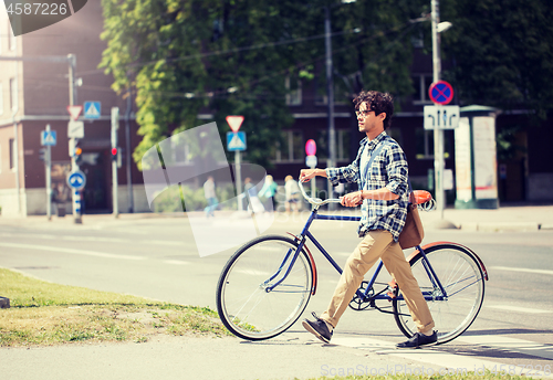 Image of young man with fixed gear bicycle on crosswalk