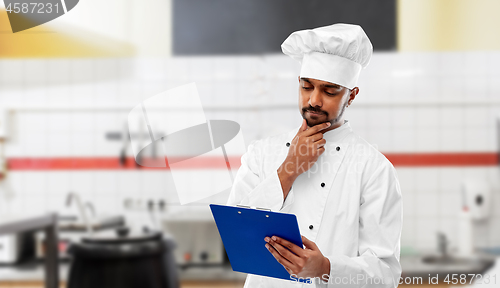 Image of indian chef with clipboard at restaurant kitchen