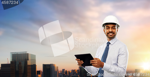 Image of architect or businessman in helmet with tablet pc