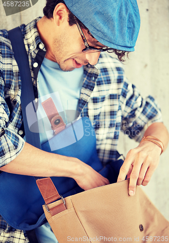 Image of close up of hipster man looking into his bag