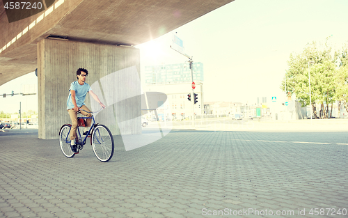 Image of young hipster man riding fixed gear bike