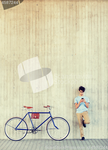 Image of man with smartphone and fixed gear bike on street