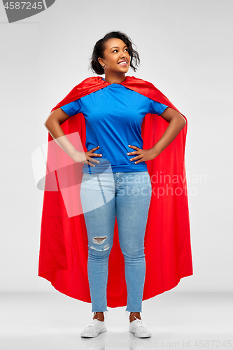 Image of happy african american woman in superhero red cape