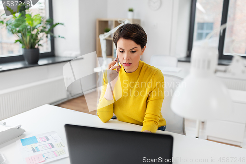 Image of ui designer calling on smartphone at office