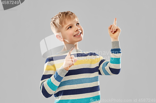 Image of little boy in striped pullover pointing finger up