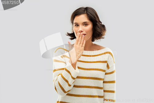 Image of happy woman covering mouth by hand and giggling