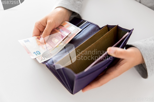 Image of close up of woman hands with wallet and euro money