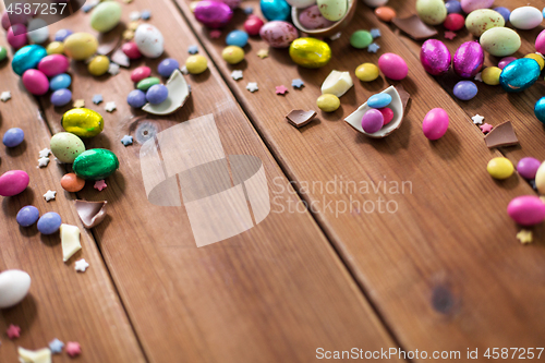 Image of chocolate eggs and candy drops on wooden table