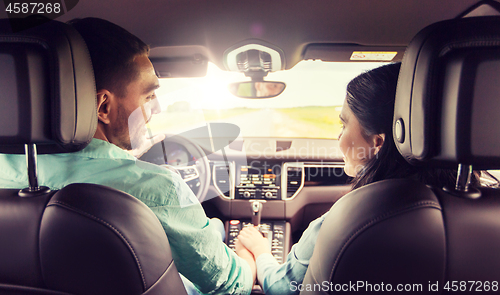 Image of happy man and woman driving in car