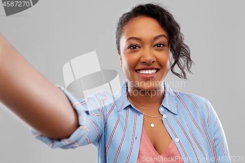 Image of happy african american woman taking selfie