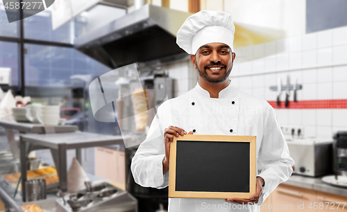 Image of happy indian chef with chalkboard at kebab shop