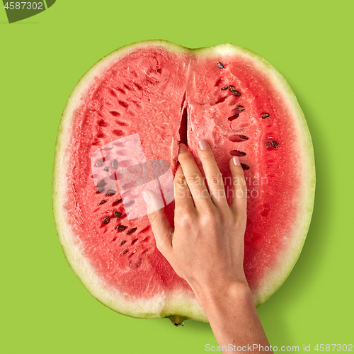 Image of Woman\'s finger touch inside watermelon ripe juicy fruit.