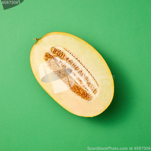 Image of Half of fresh ripe sweet melon on a seagreen background.